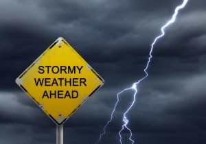 A picture of a road sign saying Stormy Weather Ahead